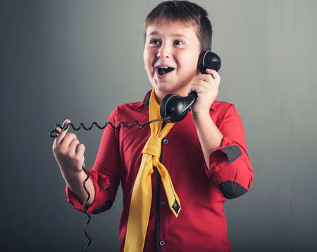 Happy kid talking on old phoneの写真素材