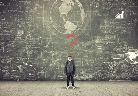 Confused boy and blackboard with formula and red question mark, asking for solutionの写真素材