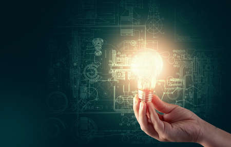 Idea concept - light bulb illuminating a blackboard with sketchesの写真素材