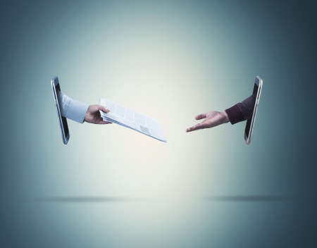 One arm reaching out resume out of smart phone to another arm coming from another smart phoneの写真素材