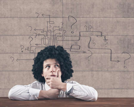 Thinking man with question mark and arrows drawing on wallの写真素材