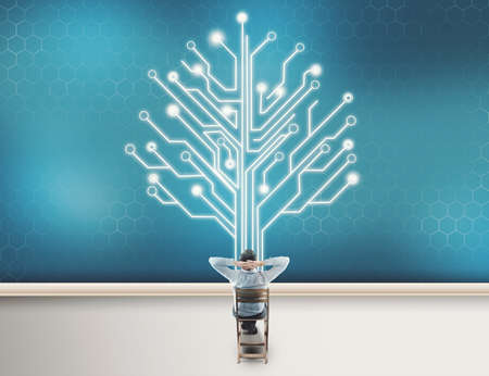 Teenager man looking at circuit board tree, network conceptの写真素材
