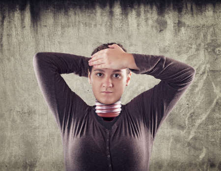 Young woman with a light bulb in place of head take off lightbulb.の写真素材