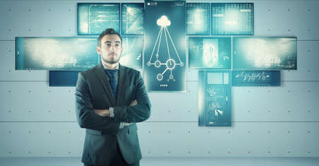 Young bussinessman in front of multi touch screens.の写真素材