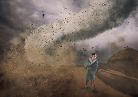 Careless man doing housework while his house is destroyed by a hurricane.の写真素材
