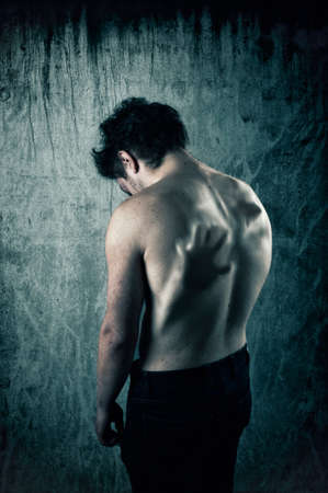 Back of a shirtless man with a person inside pushing the skin. Anxiety concept.の写真素材