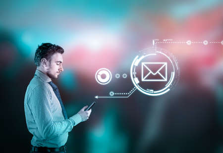 Businessman using smarphone on abstract background with bokeh lights. Sending a message hologram.の写真素材