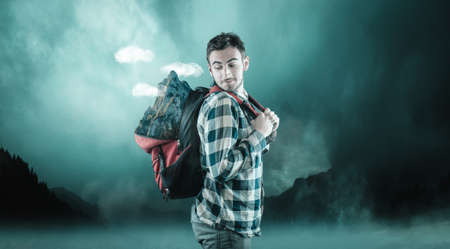 Young man carry a mountain in his backpack.の写真素材
