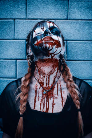 Portrait of a gothic girl wearing a black dress and a bloody make up.Halloween theme.の写真素材