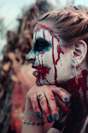 Portrait of a gothic girl wearing a black dress and a bloody make up.Halloween theme.の写真素材