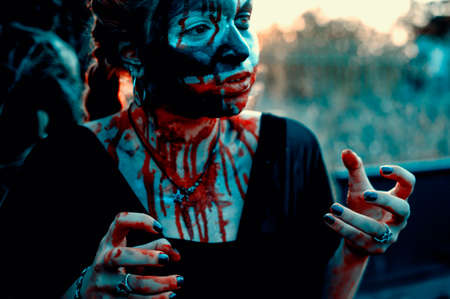 Portrait of a gothic girl wearing a black dress and a bloody make up.Halloween theme.の写真素材