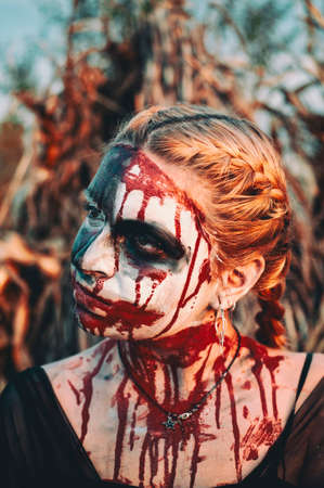 Portrait of a gothic girl wearing a black dress and a bloody make up.Halloween theme.の写真素材