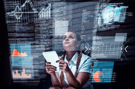 Young woman using tablet and analyze infograph code screen at home.Futuristic user interface.の写真素材