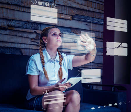 Young woman using tablet and hologram files at home.の写真素材