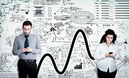 Two people using smartphones in front of a white wall drawn with math formulas .