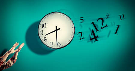 Hands catching a clock with numbers detached in the air. Lack of time concept . The concept of time...