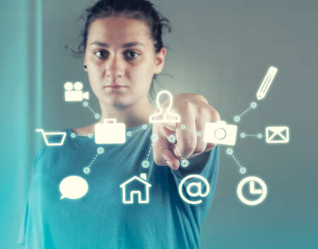 Woman pressing on a touch screen of a menu with icons .Futuristic user interface.の写真素材
