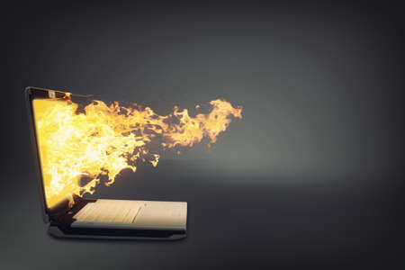 Laptop on fire isolated gray background.の写真素材