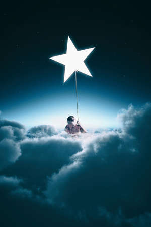 Man climbing on a rope to a star, during night above clouds.