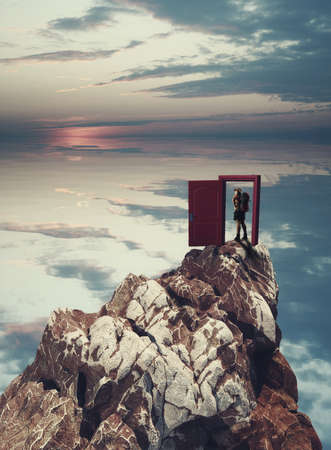 Traveler on a mountain peak opens a door.の写真素材