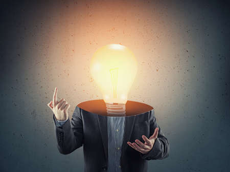 Businessman with a lit light bulb instead of head.の写真素材