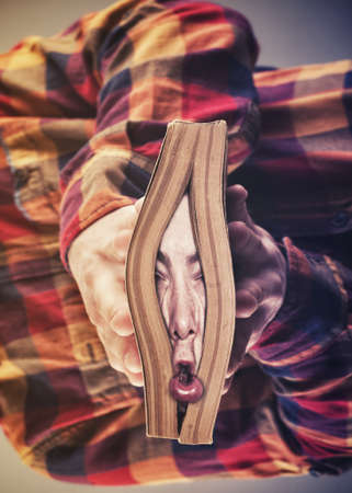 Man with his face crushed by a book. Overwhelmed concept.