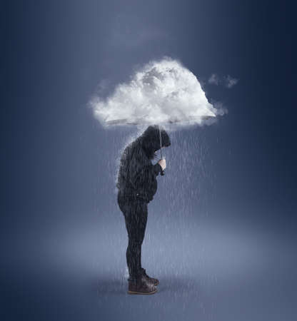 Holding an umbrella with a cloud ahead.の写真素材