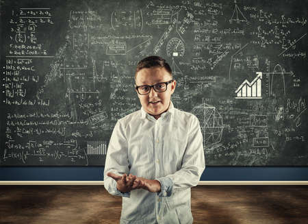 Student explaining math formulas in classroom , in front of the blackboard full of math formulas.の写真素材