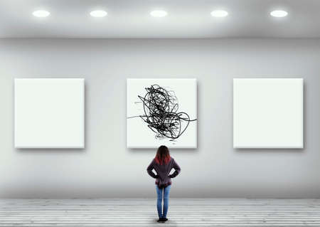 Woman looks at abstract art in the museum. The concept of out of the box.の写真素材