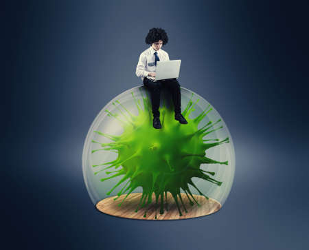 Social distancing and self-isolation during corona virus quarantine. Work from home concept . Man working online on a laptop on a bubble protection shield .の写真素材