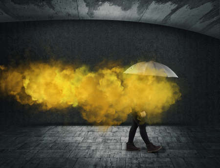 Woman holding an umbrella yellow smoke . Useless and fail concept . Anxiety and mental illness.の写真素材