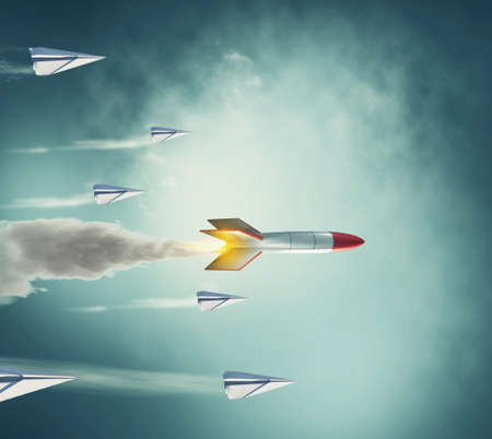 Paper plane race against a rocket missle . Team building and powerful mindset concept . This is a 3d render illustration .の写真素材