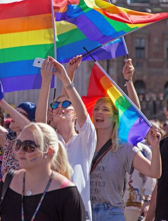 STOCKHOLM - AUG - 01. Stockholm Pride parade crossing the street with the name Skeppsbron 1 August 2015. Girl takes selfie.のeditorial素材