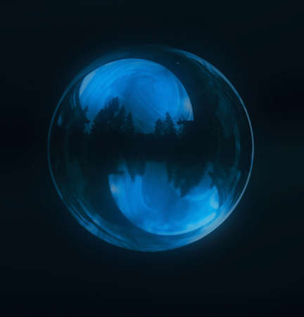 A  blue soap bubble with wood reflectionの写真素材