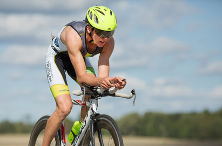 MORKO SWEDEN - AUG 29 2015: Triathlon for both exercisers and professional exerted on August 29 on an island in Sweden. Participants cycling on country road.のeditorial素材