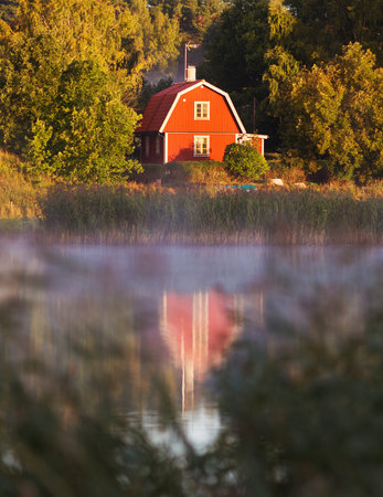 STOCKHOLM SWEDEN September 10 2015. A small Falu red cottage near the lake in a Swedish idyll.のeditorial素材