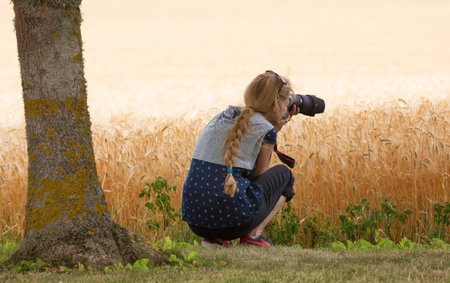 VADSTENA SWEDEN 26 July 2016. Woman photographing cornfield with his camera.のeditorial素材