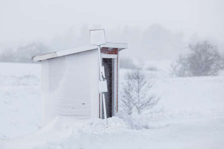 Bus stop in snowstorms in the rural environment.の写真素材