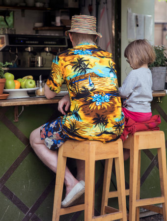 STOCKHOLM SWEDEN June 11, 2017. Father and daughter sit at a coffee bar.のeditorial素材