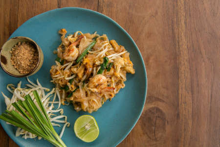Thai food Pad thai , Stir fry noodles with shrimp on wooden table - asian cuisineの写真素材