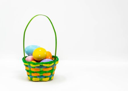Easter Eggs in a basket with a white backgroundの写真素材