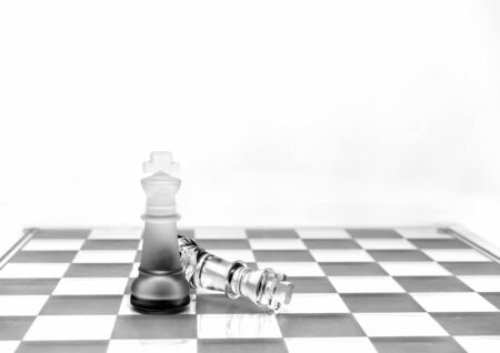 Two King chess pieces on a board in monoの写真素材