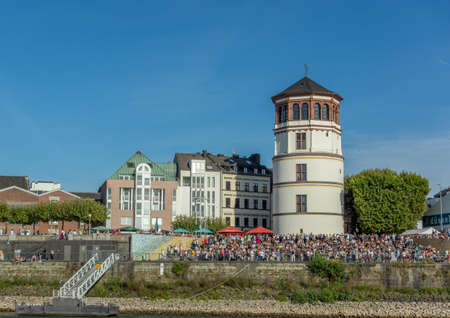 Dusseldorf, Rhineland, Germany, 09/15/2019 - a festival on the banks of the river Rhine seen from the river point of view with Burgplatz old tower.のeditorial素材