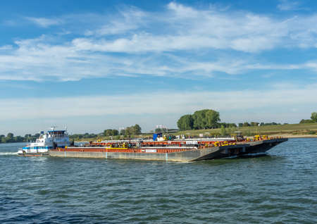 Dusseldorf, Rhineland, Germany, 09/15/2019 - tug boat with two barges on the river rhine on a sunny day with blue skyのeditorial素材