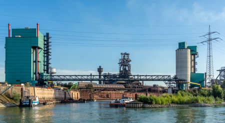 Duisburg, Rhineland, Germany, 09/15/2019 - the dock loading area for a steel coking plant with small ships and industrial background.のeditorial素材