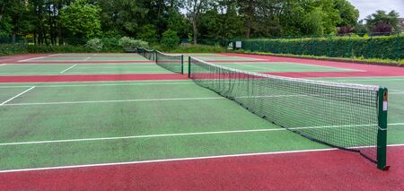 Public tennis courts with green and red marking with no players.の写真素材