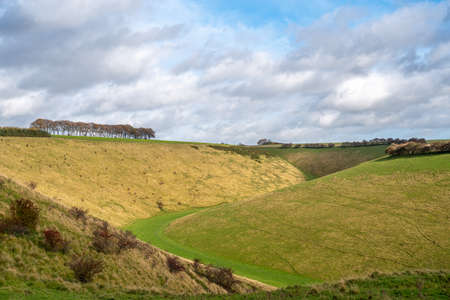 A view of Fairy Dale a valley in the Yorkshire Wolds near Burdale on a sunny day with cloudy sky.