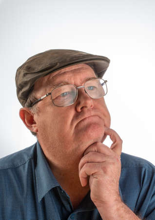Portrait of middle aged man with facial expression, with blue shirt, glasses and hat with white background.の写真素材