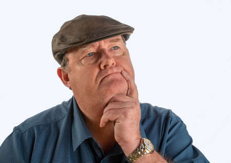 Portrait of middle aged man with facial expression, with blue shirt and hat with white background.の写真素材