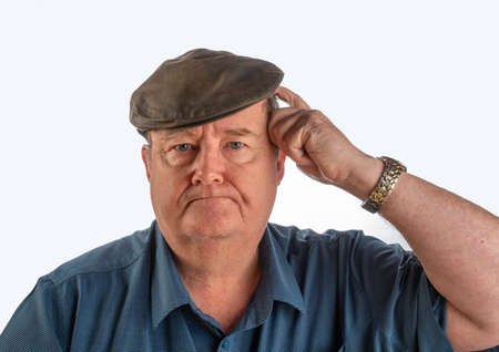Portrait of middle aged man with facial expression, with blue shirt and hat with white background.の写真素材